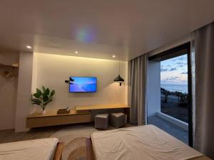 a bedroom with a tv on the wall and a bed at The Beach House by SYNCO in Lubong