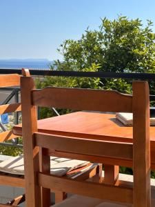 a wooden chair sitting on top of a balcony at Spilea Apartments in Himare