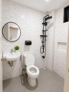 a bathroom with a toilet and a sink and a mirror at The Beach House by SYNCO in Lubong +48 photos