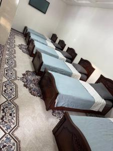 a row of beds lined up in a room at Hostel Azizjon in Samarkand