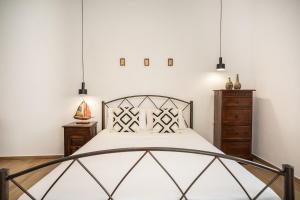 a bedroom with a bed and pendant lights at Anemoessa House in Pera Gyalos