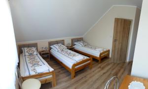 a room with three beds and a table at Zajazd u ELiZY in Czajowice