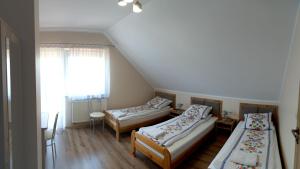 a room with three beds and a window at Zajazd u ELiZY in Czajowice