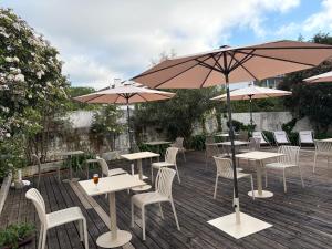 a patio with tables and chairs and umbrellas at The Literary Man Obidos Hotel in Óbidos