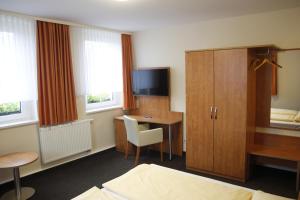 a hotel room with a desk and a bedroom at Hotel Schützenhaus Jessen in Jessen