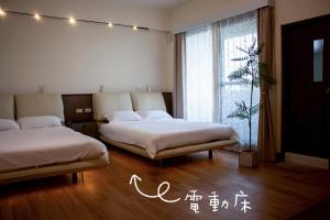 a bedroom with two beds and a window at Up villa in Taibao