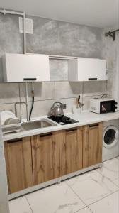 a kitchen with a sink and a washing machine at Подобово Центр in Konotop