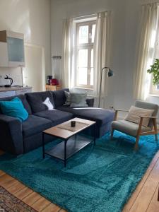 a living room with a blue couch and a table at Apartment Schloss Benrath in Greifswald
