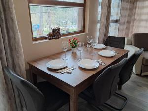 a dining room table with chairs and a wooden table and a window at Къща Шепотът на бора in Varna City +36 photos