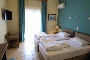 a hotel room with two beds and a window at G. Kiapekou in Loutra Edipsou