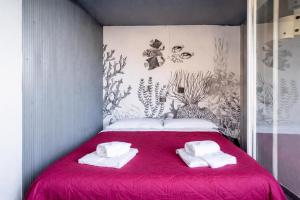a bedroom with a red bed with towels on it at Cinque Terre, Sea View Home in Manarola