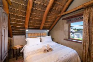 a bedroom with a bed with two slippers on it at Duivenvlugt Loft in Stilbaai