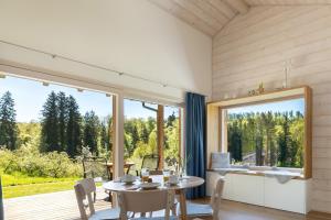 a dining room with a table and a large window at Tinyhaus Nähe Bodensee in Neukirch