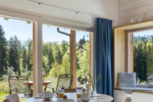 a dining room with a table and a large window at Tinyhaus Nähe Bodensee in Neukirch +20 photos