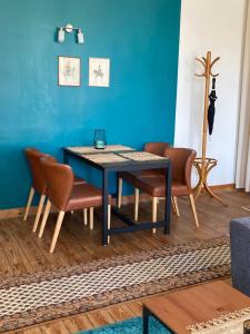 a dining room table with chairs and a blue wall at Apartment Schloss Benrath in Greifswald