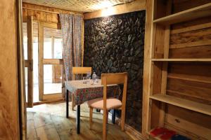 a dining room with a table and chairs and a stone wall at Noble Cheer in Ruhengeri +40 photos