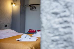 two beds in a room with white towels on them at La Stanza Rossa alle Cinque Terre in Manarola
