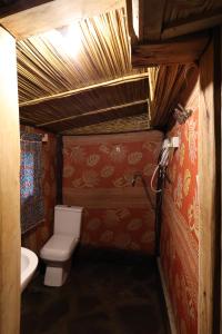a small bathroom with a toilet and a sink at Noble Cheer in Ruhengeri
