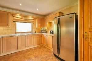 a kitchen with a stainless steel refrigerator and wooden cabinets at Host & Stay - Lodge 32 in Belton