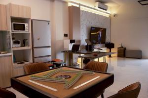 a dining room with a table with chairs and a refrigerator at Up villa in Taibao