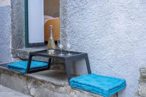 a table with a bottle of wine and two blue cushions at La Stanza Rossa alle Cinque Terre in Manarola +2 photos