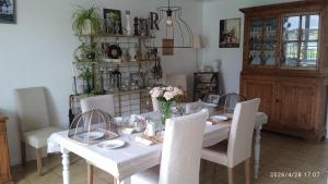 a dining room with a white table and chairs at Le Ronsard in Blye