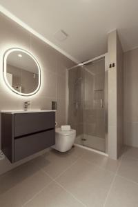a bathroom with a toilet and a sink and a shower at Casa Jacinto 9 in Caldas da Rainha
