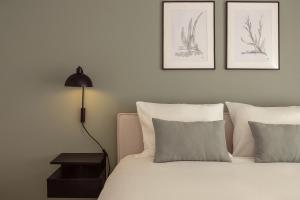 a bedroom with a bed with two pillows and a lamp at Casa Jacinto 9 in Caldas da Rainha +3 photos