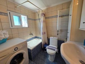 a bathroom with a toilet and a sink and a washing machine at Peramos Sea View in Nea Peramos +24 photos