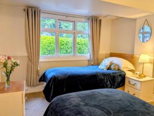 two beds in a room with a window at Lee House in Lynton