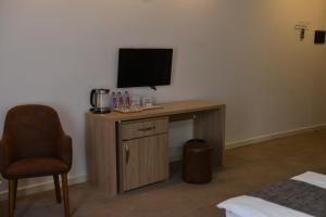 a room with a desk with a television and a chair at Noor-ZamZam-Madinah Halal Hotels Group in Baku