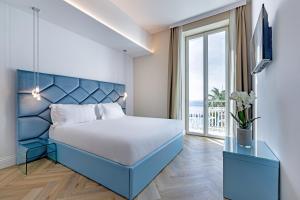 a bedroom with a blue bed and a large window at Miramare The Palace Resort in Sanremo +196 photos
