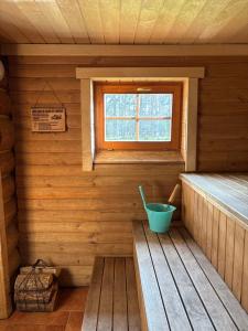 an inside of a sauna with a blue bucket at Kuningatalu Palkmaja in Roosisaare