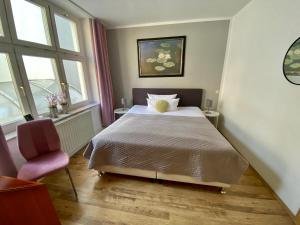 ein Schlafzimmer mit Bett, Stuhl und Fenstern in der Unterkunft Bärliner Hotel in Erfurt + 72 Fotos