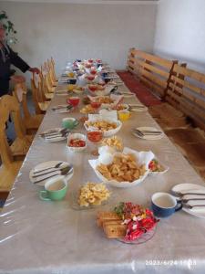 a long table filled with plates and bowls of food at Bugu Too Guest House in Kaindy +6 photos