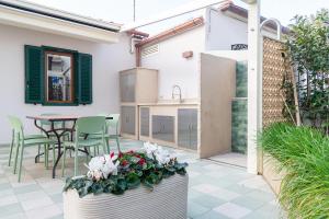 a patio with a table and chairs and a kitchen at Villa in Spiaggia in Follonica