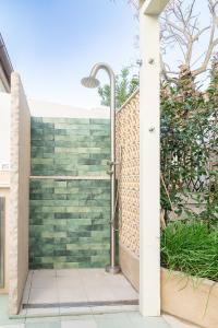 a shower in a bathroom with a brick wall at Villa in Spiaggia in Follonica +35 photos