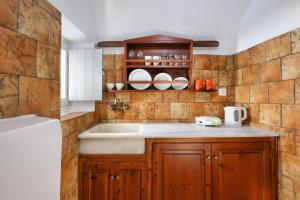 a kitchen with a sink and a white refrigerator at ROCK CAVE HOUSE in Oia