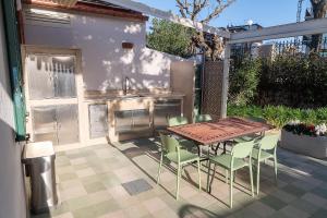 a patio with a table and chairs and a kitchen at Villa in Spiaggia in Follonica