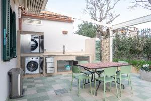 a patio with a table and chairs and a washing machine at Villa in Spiaggia in Follonica