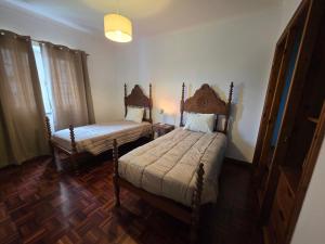 a bedroom with two beds in a room at Casa Pascoal in Ribeira Grande