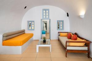 a living room with two couches and a table at ROCK CAVE HOUSE in Oia