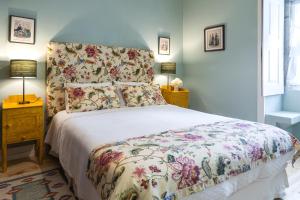 a bedroom with a bed with a floral bedspread at Casa da Azenha in Peso da Régua +49 photos