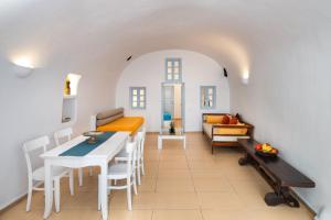 a living room with a table and a couch at ROCK CAVE HOUSE in Oia