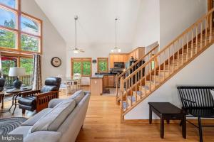 a living room with a couch and a staircase at Shenandoah A-Frame Chalet at Bryce Resort in Basye