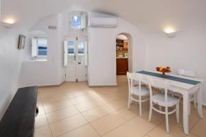 a kitchen and dining room with a table and chairs at ROCK CAVE HOUSE in Oia +7 photos