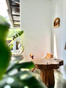 a tree stump table in a room with a plant at Terima Kasih Malang Hostel in Malang