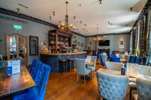 a restaurant with tables and chairs and a bar at Crescent Inn by Maison Pierre in Ilkley +23 photos