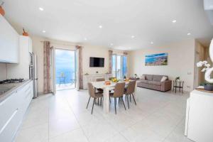 a kitchen and living room with a table and chairs at Coastal Escape, Amalfi in San Lazzaro Agerola