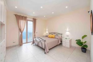 a bedroom with a bed and a large window at Coastal Escape, Amalfi in San Lazzaro Agerola